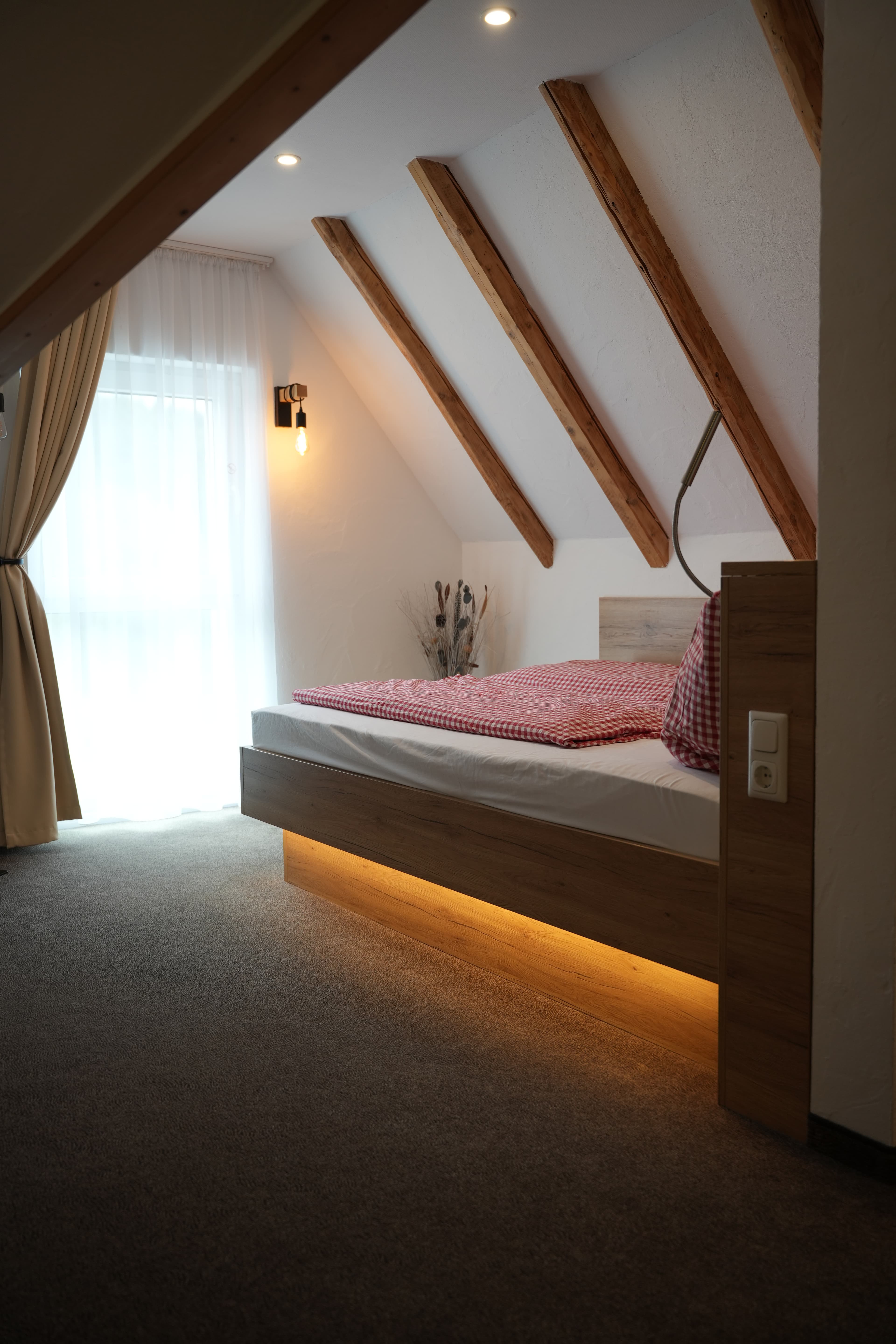 Schlafzimmer einer Pension mit sichtbaren Holzbalken